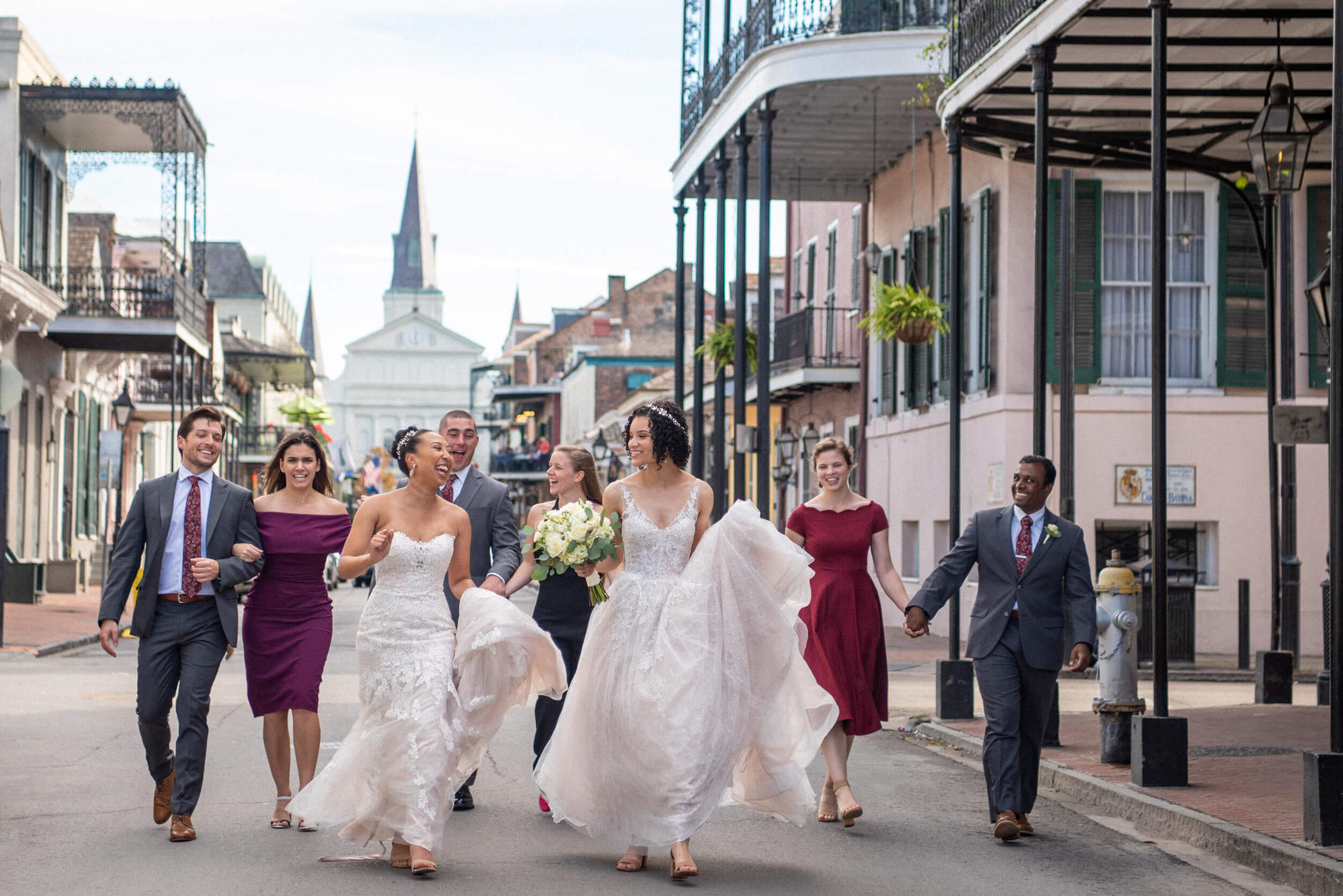 Lesbian brides and their wedding party on their way to their New Orleans French Quarter wedding.