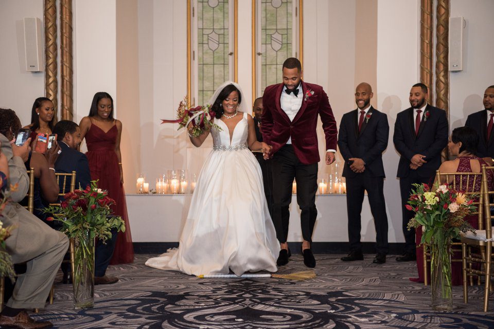 African American couple jumping the broom at their wedding in the chapel at the Hilton New Orleans - St. Charles Avenue
