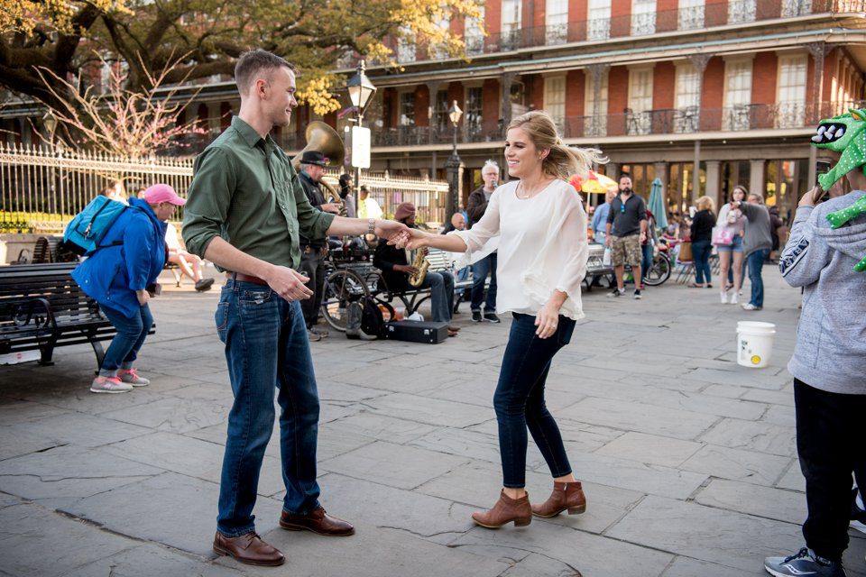 Engaged couple dancing their engagement photography session outside Jackson Square